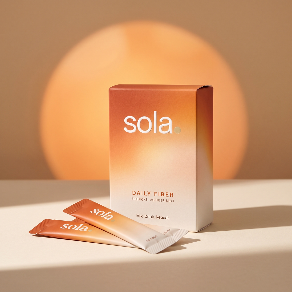 Sola Daily Fiber box and stick packs in front of a warm orange glow